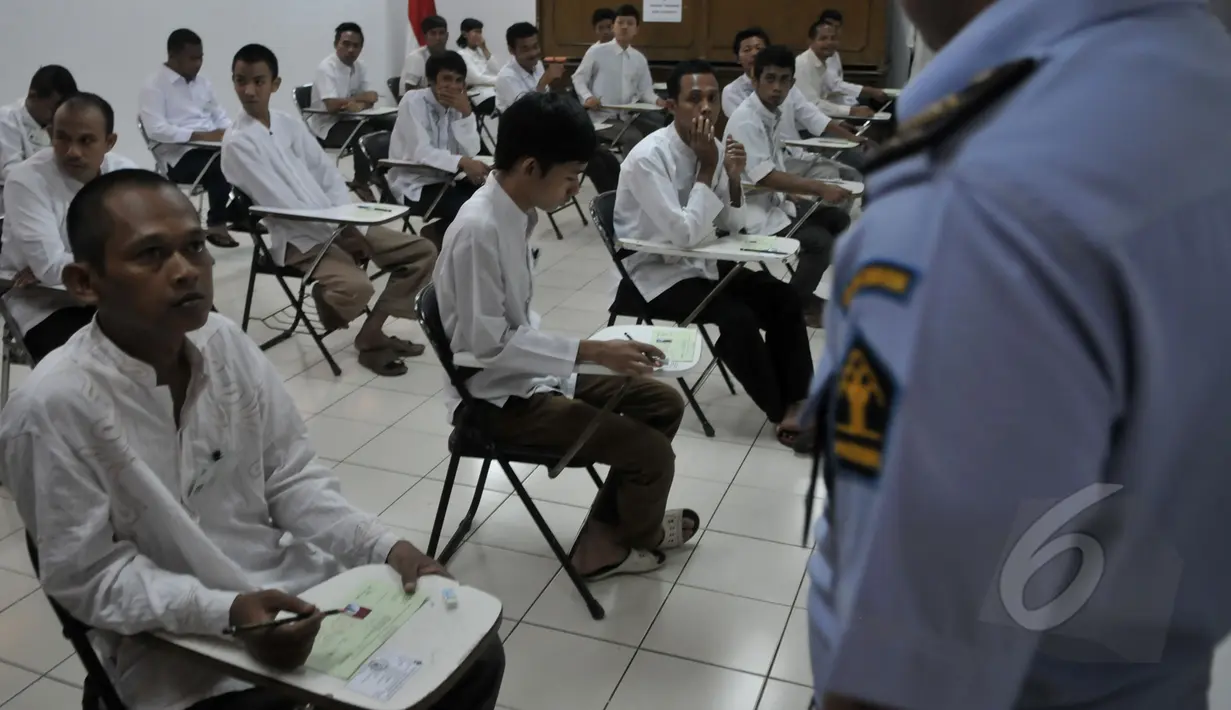Seorang napi peserta UN menanyakan sesuatu kepada petugas saat UN 2015 digelar di LP Narkotika Cipinang, Jakarta, Senin (13/4/2015).  Para peserta terlihat bersemangat menjalani UN 2015. (Liputan6.com/Johan Tallo)