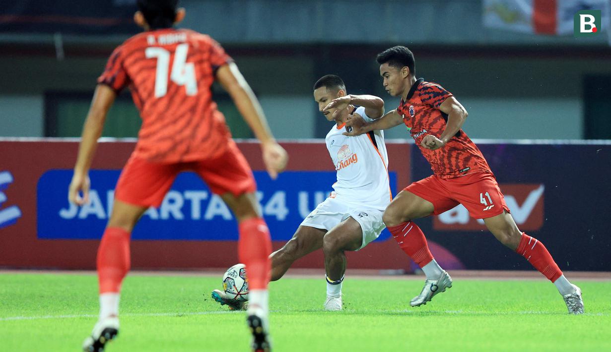 Pemain Ratchaburi FC, Faiq Jefri Bolkiah (tengah), memberikan umpan dibayangi pemain Persija Jakarta, Muhammad Ferarri (kanan), dalam pertandingan uji coba yang berlangsung di stadion Patriot Candrabhaga, Bekasi, Minggu (25/6/2023). (Bola.com/M Iqbal Ichsan)