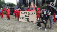 Sejumlah aktivis Indonesia Corruption Watch (ICW) dan Gerakan #BersihkanIndonesia melakukan aksi teatrikal saat unjuk rasa di depan Gedung KPK, Jakarta, Rabu (8/12/2021). Aksi dalam rangka memperingati Hari Anti Korupsi Sedunia pada 9 Desember 2021. (Liputan6.com/Herman Zakharia)