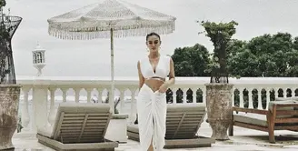 Penyanyi Indonesia Go Internasional ini tampil serba putih dengan atasan crop top dipadukan kain putih sebagai bawahan. (@agnezmo)