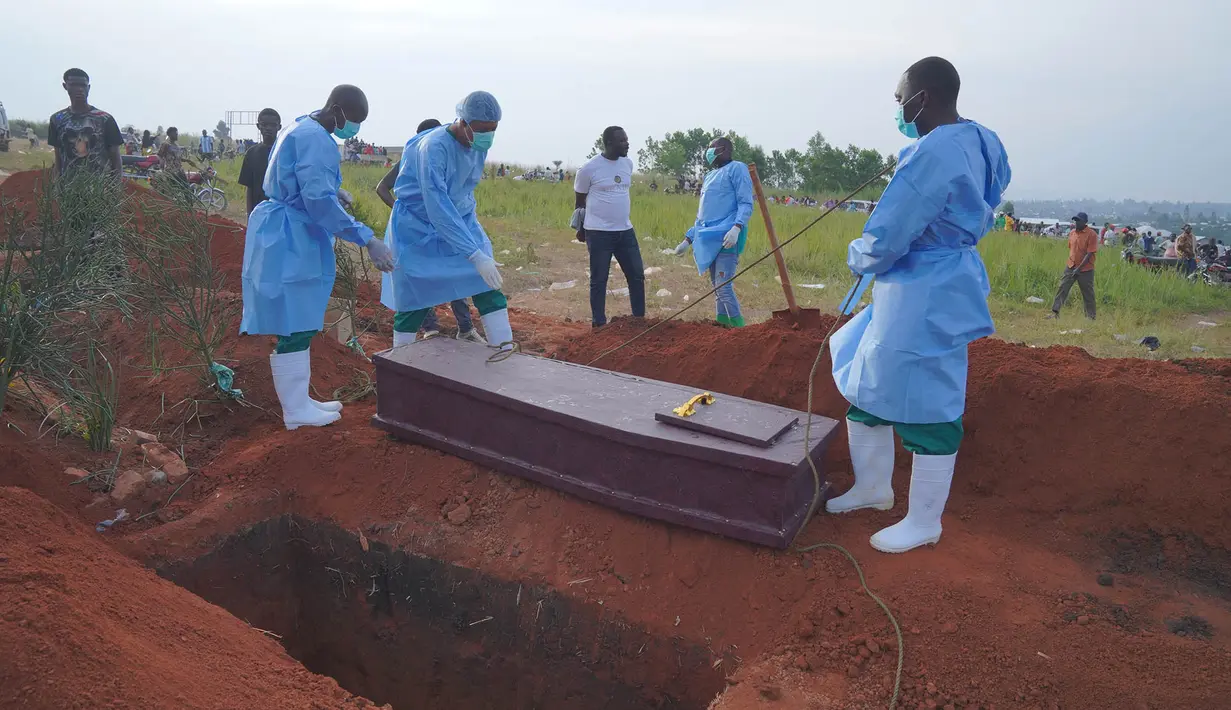 Orang-orang yang mengenakan pakaian pelindung bersiap menurunkan peti jenazah seorang anak berusia enam tahun yang meninggal akibat Ebola, ke dalam liang lahat di Bunia, Provinsi Ituri, Kongo timur, Selasa, 18 Agustus 2026. (Foto AP/Dieudonne Dirole)