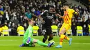 Penjaga gawang Barcelona Marc-Andre ter Stegen (kiri) melakukan penyelamatan di depan pemain Real Madrid Vinicius Junior (tengah) pada pertandingan sepak bola La Liga Spanyol di Stadion Santiago Bernabeu, Madrid, Spanyol, Minggu (20/3/2022). Barcelona menang 4-0. (AP Photo/Manu Fernandez)