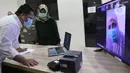 Wakil Gubernur DKI Ahmad Riza Patria berbincang secara virtual dengan salah satu pasien Covid-19 saat meninjau meninjau RSUD khusus Covid-19 di Pasar Minggu, Jakarta, Sabtu (3/10/2020). Kunjungan Riza untuk memastikan langsung penanganan pasien yang terpapar Covid-19. (Liputan6.com/Herman Zakharia)