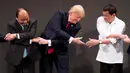 Tangan kanan Presiden AS, Donald Trump berusaha menjabat tangan Presiden Filipina, Rodrigo Duterte saat salaman khas ASEAN di upacara pembukaan KTT ASEAN, Manila, Senin (13/11). Trump tampak sulit mengikuti gaya salaman pemimpin lainnya (AP/Andrew Harnik)