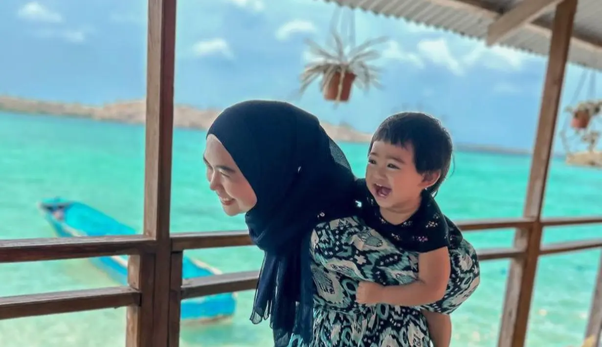 Liburan ke Maluku Tenggara, Ria mengenakan gamis warna biru bermotif. Sedangkan Moana tampil dengan baju hitam. [@riaricis1795]