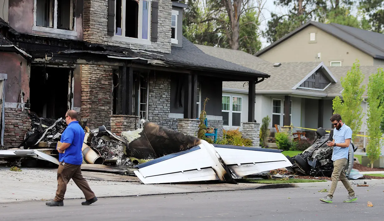 Pejabat Federal Aviation Administration menyelidiki lokasi pesawat yang sengaja menabrak rumah di Payson, Utah, AS, Senin (13/8). Istri dan putra sang putra yang berada di dalam rumah dapat menyelamatkan diri. (Scott G Winterton/The Deseret News via AP)