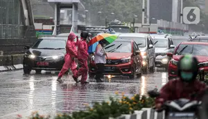 Pejalan kaki yang menggunakan payung saat hujan deras menyeberang jalan di kawasan Thamrin, Jakarta, Rabu (23/11/2022). Sejak Oktober, DKI Jakarta mulai memasuki musim penghujan yang sudah masuk ke dalam tahap ekstrem. (Liputan6.com/Faizal Fanani)