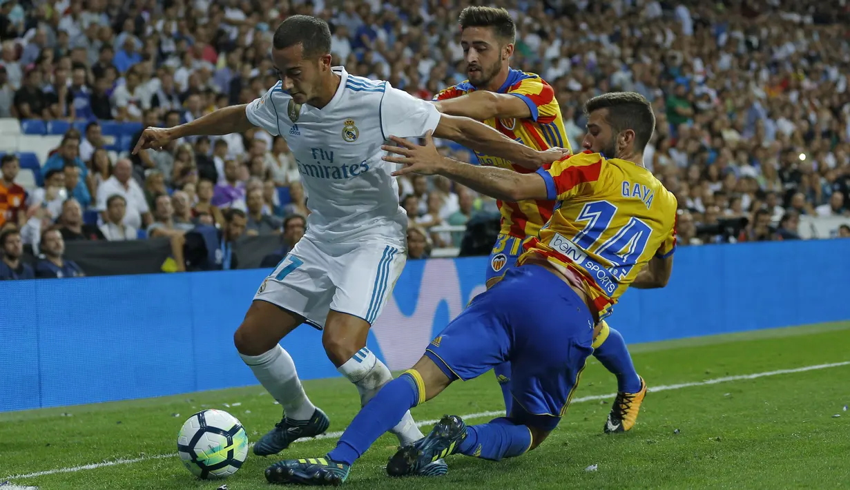 Aksi pemain Real Madrid, Lucas Vazquez (kiri) melewati adangan dua pemain Valencia pada lanjutan La Liga Spanyol di Santiago Bernabeu stadium, Madrid, (27/8/2017). Real ditahan Imbang 2-2. (AP/Francisco Seco)