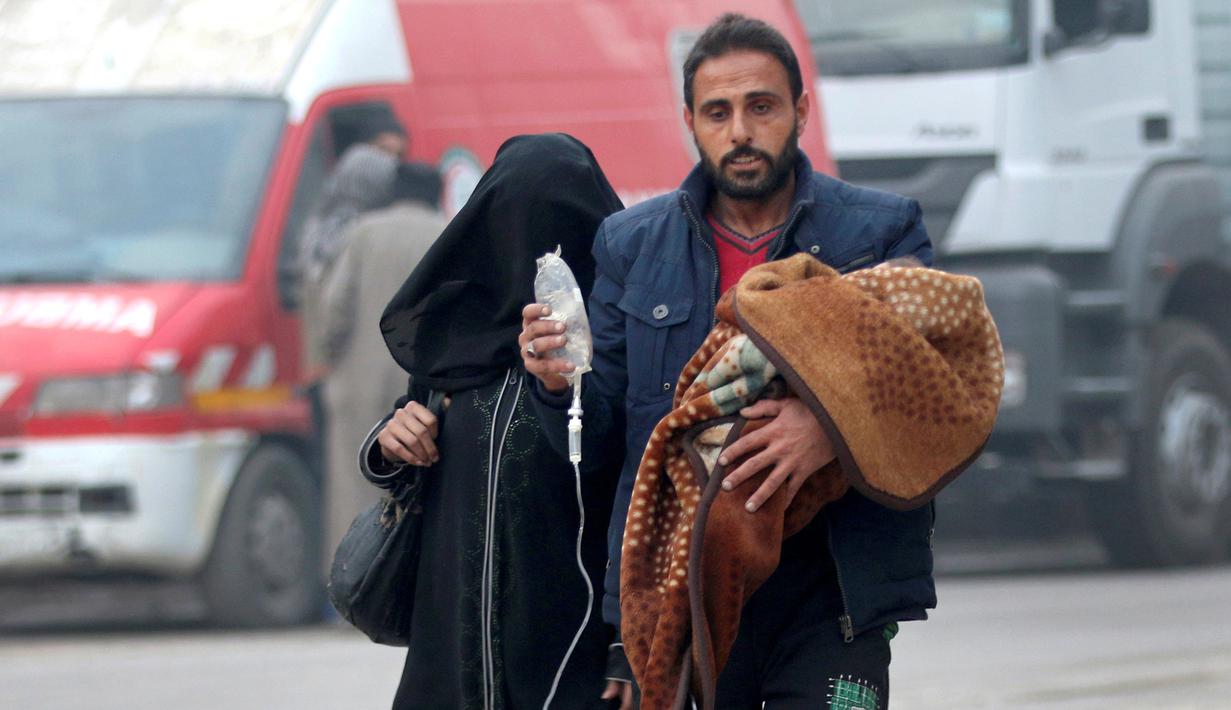 Seorang pria membawa anak dengan infus saat ia melarikan diri lebih dari wilayah yang dikuasai pemberontak di Aleppo, Suriah (12/12). (REUTERS / Abdalrhman Ismail)
