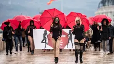 Sejumlah wanita pekerja seks menggenakan busana hitam dan topeng serta membawa payung merah berunjuk rasa di Skopje (17/12). Para pekerja seks ini memprotes kekerasan yang mereka alami, dan hukuman untuk klien prostitusi. (AFP Photo/Robert Atanasovski)