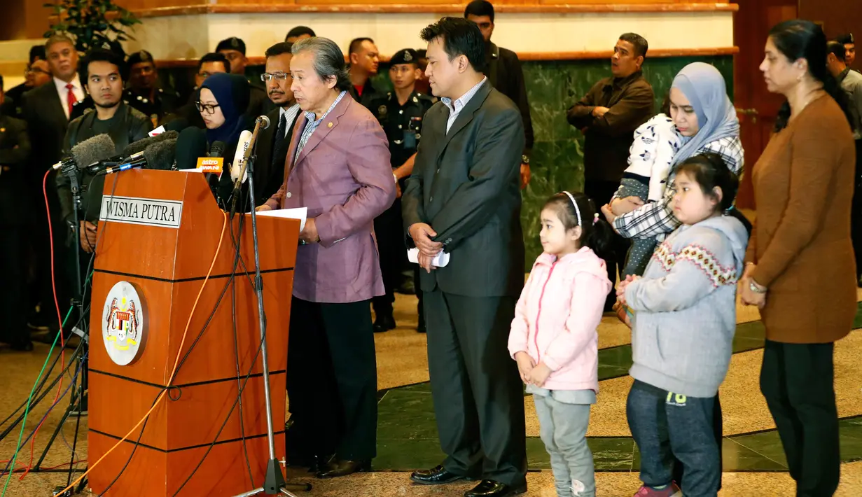 Menlu Malaysia Anifah Aman, didampingi warganya yang baru meninggalkan Korea Utara, memberikan keterangan di Bandara Kuala Lumpur, Jumat (31/3). Sembilan warga Malaysia yang berada di Korut itu ditukar dengan jasad Kim Jong-nam. (AP Photo/Vincent Thian)