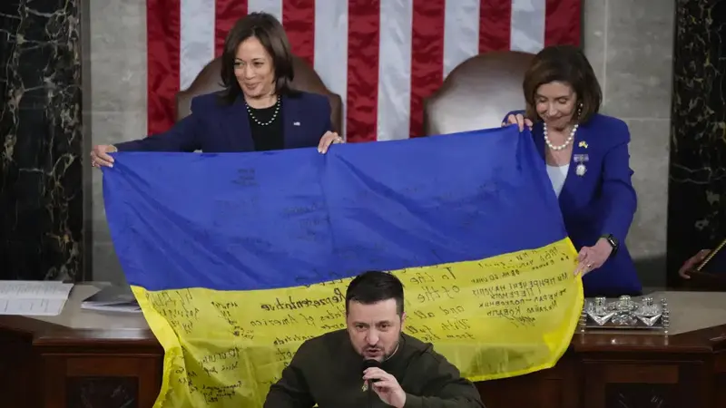 Presiden Ukraina Volodymyr Zelensky berpidato di pertemuan gabungan Kongres di Capitol Hill di Washington, Rabu, 21 Desember 2022. Ia menyerahkan bendera Ukraina yang ditandatangani oleh pasukan garis depan di Bakhmut. (AP Photo/Jacquelyn Martin)