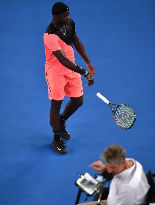 Frances Tiafoe dari AS melempar raketnya saat ia berjalan keluar lapangan setelah kehilangan set kedua pada putaran tunggal putra pertamanya melawan petenis Argentina Juan Martin del Potro di Australia Terbuka di Melbourne (16/1). (AFP Photo/Greg Wood)