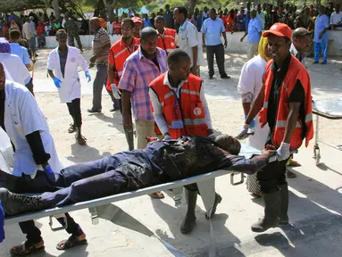 Petugas membawa korban dari serangan bom mobil di Mogadishu, Somalia, Rabu (25/1). Kelompok Alshabaab mengklaim berada di balik serangan tersebut. (AP Photo)