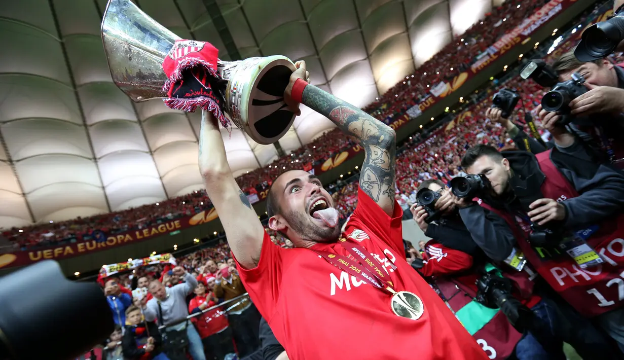 Aleix Vidal mengangkat trofi di tengah perayaan gelar Liga Europa 2015 di Stadion Narodowy, Polandia, Kamis (28/5/2015). Sevilla memecahkan rekor meraih trofi Liga Europa terbanyak, yakni empat gelar. (Reuters/Eddie Keogh)