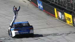 Pembalap dari Comcast Business Toyota, Carl Edwards berdiri di pintu mobil saat merayakan kemenangan NASCAR Sprint Cup Series Food City 500 di Bristol Motor Speedway (17/4). (AFP/Matt Sullivan)