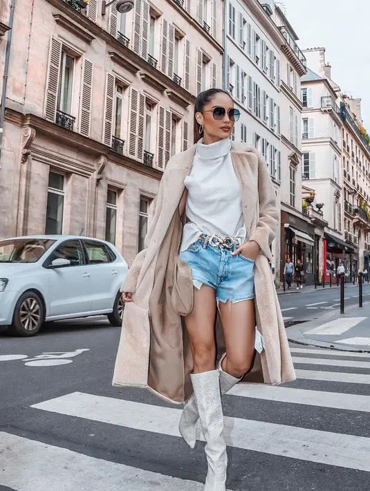 Selanjutnya bisa tiru gaya parisian ala Cinta Laura yang mengenakan turtleneck top, long coat, dan denim shorts. [@claurakiehl]