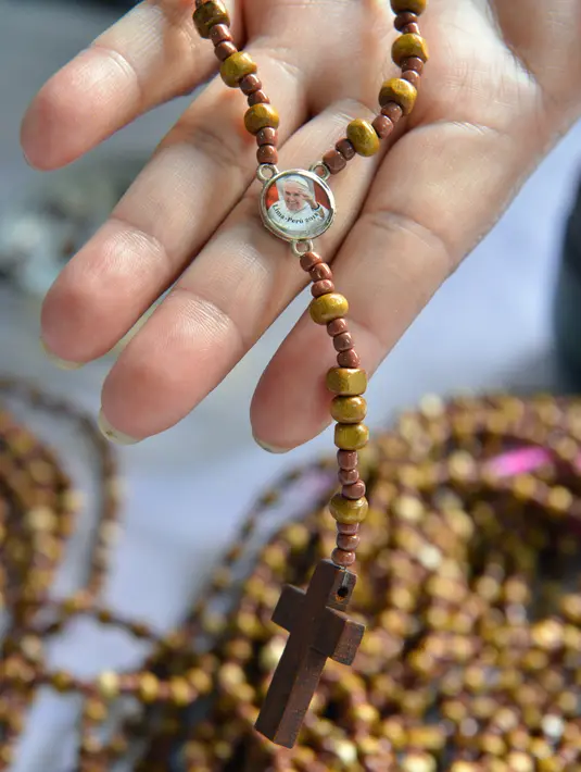 Seorang narapidana di penjara Wanita Virgen de Fatima mununjukkan rosario kayu buatan tangannya di Lima, Peru (12/1). Penjara tersebut menghasilkan 33.000 rosario untuk dijual di toko-toko ibukota Peru, Lima. (AFP Photo/Cris Bouroncle)