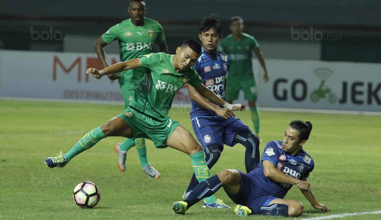 Bek Arema FC, Beny Wahyudi, berusaha menghadang gelandang Bhayangkara FC, Dendy Sulistyawan, pada laga Liga 1 di Stadion Patriot, Bekasi, Jumat (4/8/2017). Bhayangkara FC menang 2-1 atas Arema FC. (Bola.com/M Iqbal Ichsan)