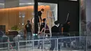 Para staf memperbaiki pintu kaca sebuah toko furnitur di pusat perbelanjaan Siam Paragon. (Lillian SUWANRUMPHA/AFP)