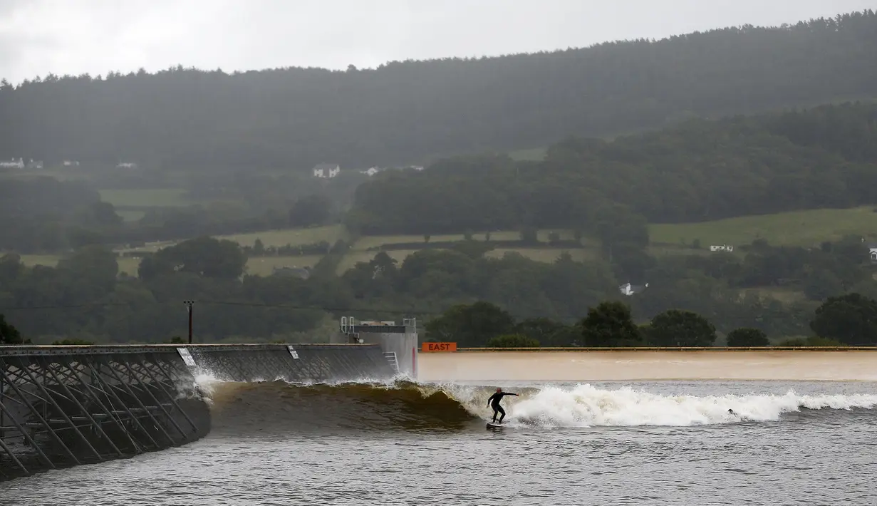 Seorang peselancar berselancar di Surf Snowdonia, Conwy, North Wales, Kamis (3/9/2015). Ukuran tinggi gelombang di Danau buatan ini bisa mencapai 300 meter dan panjang 110 meter dan berisi sekitar enam juta galon air . (REUTERS/Andrew Yates) 