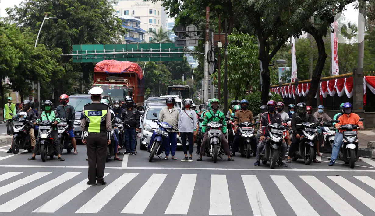 Pengendara berhenti di perempatan Bank Indonesia jalan MH Thamrin, Jakarta, Senin (17/8/2020). Dalam rangka HUT ke-75 tahun Kemerdekaan Indonesia, masyarakat menghentikan aktivitas selama tiga menit sebagai bentuk penghormatan detik-detik proklamasi. (Liputan6.com/Helmi Fithriansyah)