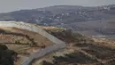Sebuah foto yang diambil dari Israel memperlihatkan perbatasan yang memisahkan Israel utara dari Lebanon selatan, dengan desa Lebanon Ain Ebel terlihat di latar belakang pada 16 November 2025. Israel membangun tembok perbatasan baru di sepanjang garis perbatasan dengan Lebanon wilayah bagian Selatan. (Jalaa MAREY/AFP)