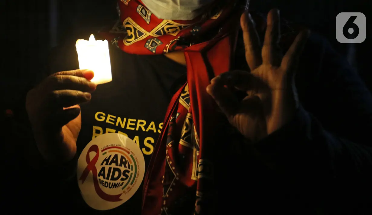 Seorang relawan menyalakan lampu pada malam renungan Hari AIDS Sedunia di Tanah Abang, Jakarta, Rabu (1/12/2021). Acara ini mengampanyekan kepada masyarakat untuk mewaspadai penularan virus HIV/AIDS dan lebih berempati pada penderitanya. (Liputan6.com/Herman Zakharia)