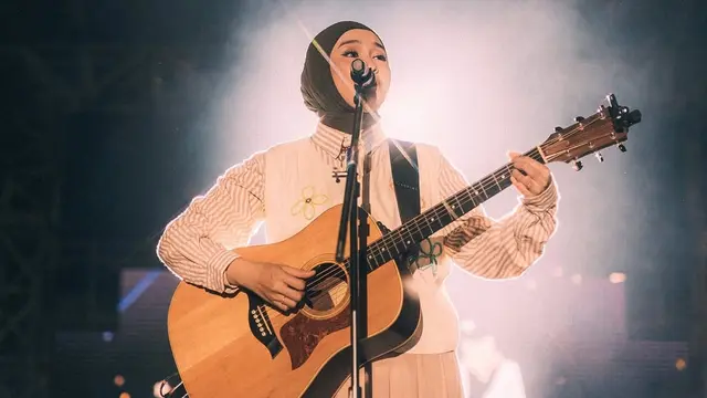 Salma Salsabila tampil dengan gitar di atas panggung