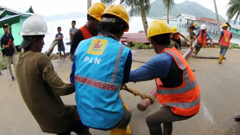 Karyawan PT PLN (Persero) bergotong rotong mengangkat tiang yang akan digunakan untuk penyangga kabel listrik di Natuna, Kepulauan Riau. (Foto: Humas PLN)