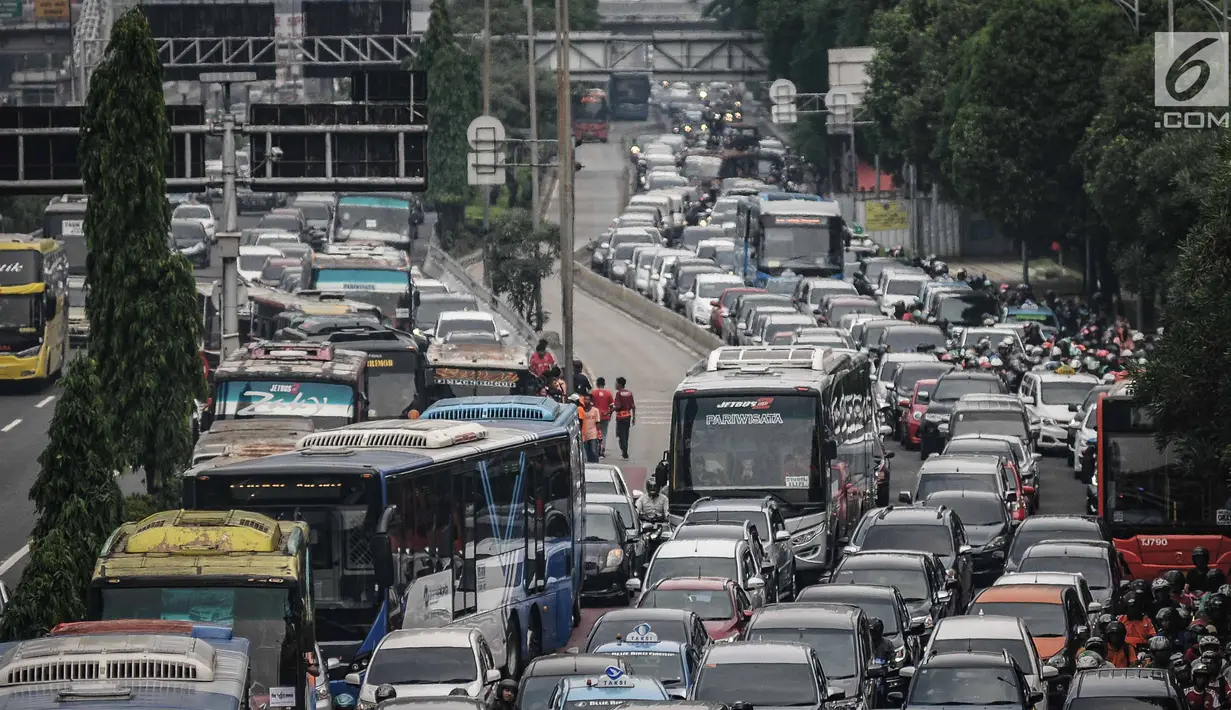 Kendaraan roda dua dan empat tampak terjebak macet panjang di kawasan Jalan Gatot Subroto, Jakarta, Minggu (9/12). Kemacetan tersebut diakibatkan oleh ribuan suporter yang ingin menunju ke Stadion Gelora Bung Karno. (Liputan6.com/Faizal Fanani)