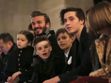 Mantan pesepakbola, David Beckham duduk di barisan depan bersama anak-anaknya Harper, Cruz, Romeo dan Brooklyn menyaksikan koleksi busana terbaru milik sang istri Victoria Beckham Fall/Winter 2016 di New York Fashion Week (14/2). (REUTERS/Andrew Kelly)