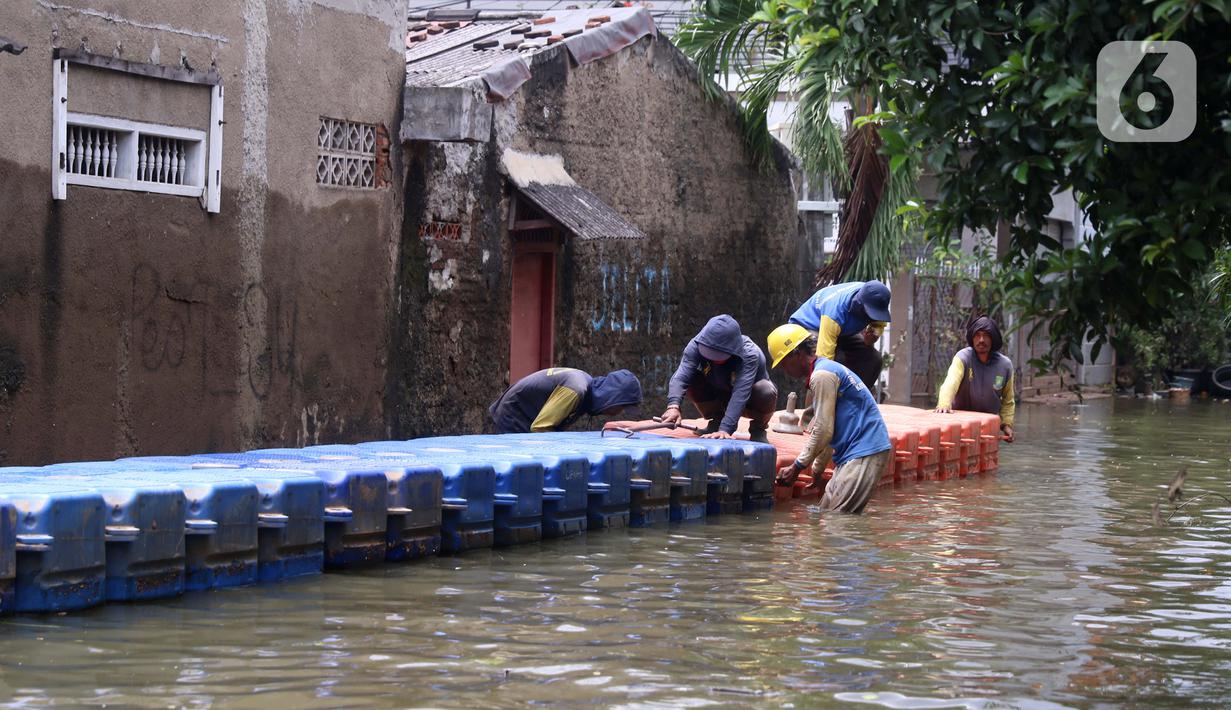 Petugas membuat jembatan apung saat banjir melanda Perumahan Periuk Damai, Tangerang, Banten, Selasa (23/2/2021). Adanya jembatan apung mempermudah warga saat melintasi banjir setinggi 2,5 meter di tempat tersebut. (Liputan6.com/Angga Yuniar)