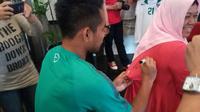 Andik Vermansah memberi tanda tangan jersey milik penggemar jelang laga Timnas Indonesia melawan Vietnam. (Bola.com/Okie Prabhowo)