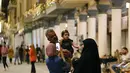 Warga Irak berfoto di Jalan Mutanabi Baghdad, Irak (18/5/2022). Jalan Al-Mutanabbi merupakan pusat jual beli buku yang bersejarah di Baghdad, sebuah jalan yang dipenuhi toko-toko buku dan lapak-lapak penjual buku. (AP Photo/Hadi Mizban)