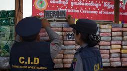Aparat kepolisian Myanmar memeriksa narkotika sitaan sebelum acara pemusnahan pada Hari Antinarkoba Sedunia, di Yangon, Senin (26/6). Myanmar membakar opium, heroin, dan kokain senilai sekitar US$385 juta, setara Rp5,1 miliar. (AP Photo/Thein Zaw)