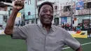 <p>Mantan pemain sepak bola asal Basil, Edson Arantes do Nascimento atau Pele mengangkat tinjunya saat upacara peresmian lapangan sepak bola berteknologi baru yang dipasang di Favela Mineira, Rio de Janeiro, Brasil, 10 September 2014. Pele memiliki segudang rekor di Piala Dunia yang belum bisa dipecahkan hingga tahun 2022 ini, seperti pemenang Piala Dunia termuda di usia 17 tahun dan 249 hari dan pencetak gol termuda di Piala Dunia berkat golnya ke gawang Wales di umur 17 tahun dan 239 hari. (Yasuyoshi CHIBA/AFP)</p>