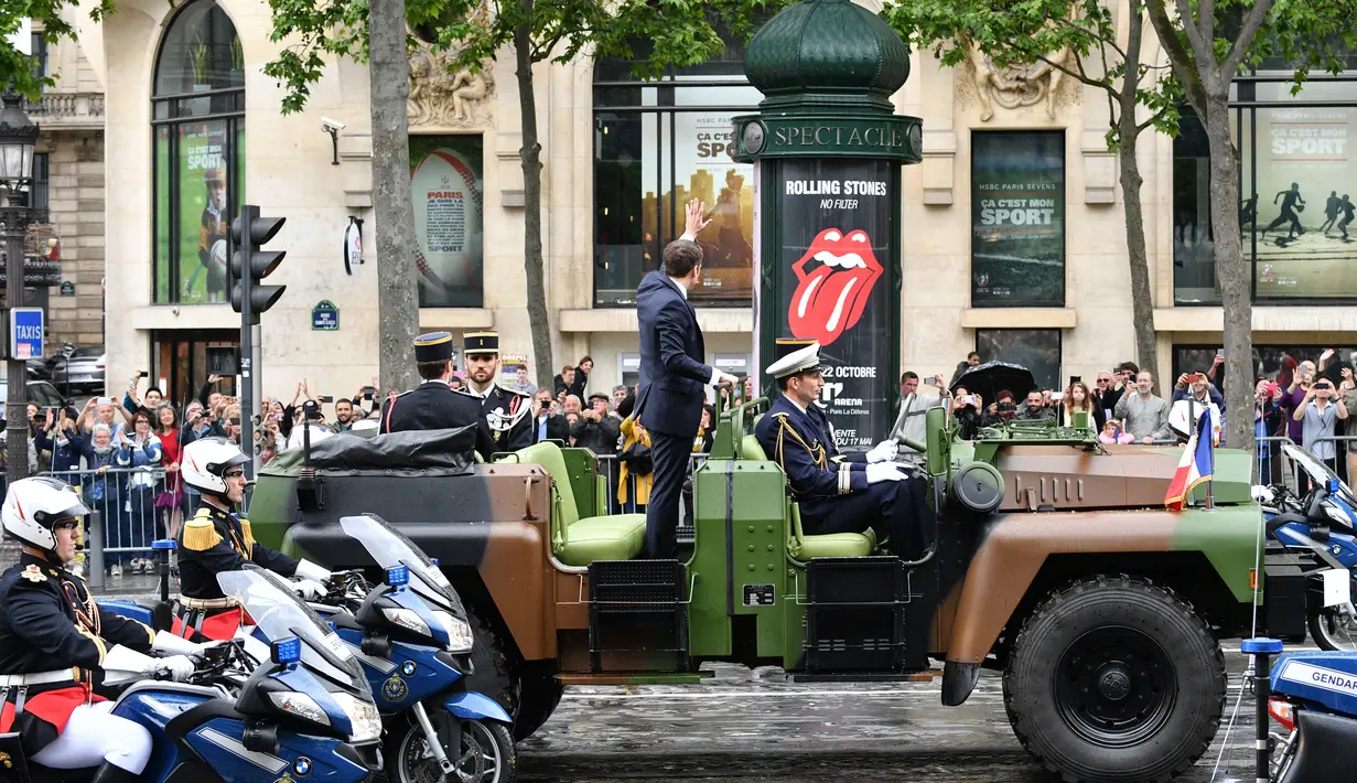 Presiden terpilih Prancis Emmanuel Macron menyapa warga saat berparade di jalan Champs Elysees setelah upacara peresmian sebagai Presiden Prancis, Paris, Minggu (14/5). (AFP PHOTO / CHARLY TRIBALLEAU)