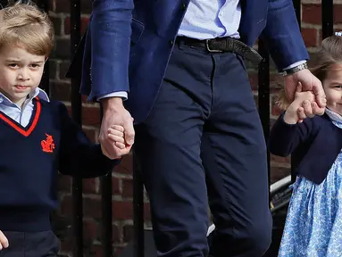 Pangeran George dan Putri Charlotte mengunjungi tempat sang ibu, Kate Middleton melahirkan di Rumah Sakit St Mary's, London, Senin (23/4). Pangeran George dan Putri Charlotte tampil senada dengan busana serba biru. (AP/Kirsty Wigglesworth)