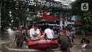 Petugas menggunakan perahu karet mengangkut warga melintasi banjir di kawasan Green Garden, Jakarta Barat, Selasa (25/2/2020). Hujan yang mengguyur kawasan Jakarta membuat kawasan tersebut tergenang banjir setinggi 60-80 cm. (Liputan6.com/Johan Tallo)