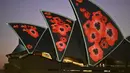 Layar Opera House diterangi dengan proyeksi bunga poppy  selama Remembrance Day Dawn Service di Sydney, Jumat (11/11/2022). Lebih dari 60.000 orang Australia tewas dalam pertempuran selama empat tahun konflik global tersebut.. (Saeed KHAN / AFP)