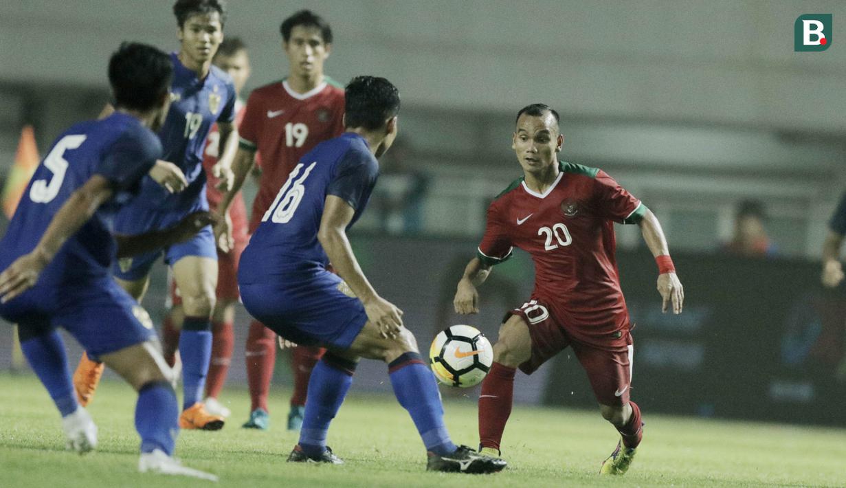 Gelandang Timnas Indonesia, Riko Simanjuntak, berusaha melewati pemain Thailand saat pertandingan persahabatan di Stadion Pakansari, Bogor, Minggu, (03/6/2018). (Bola.com/M Iqbal Ichsan)