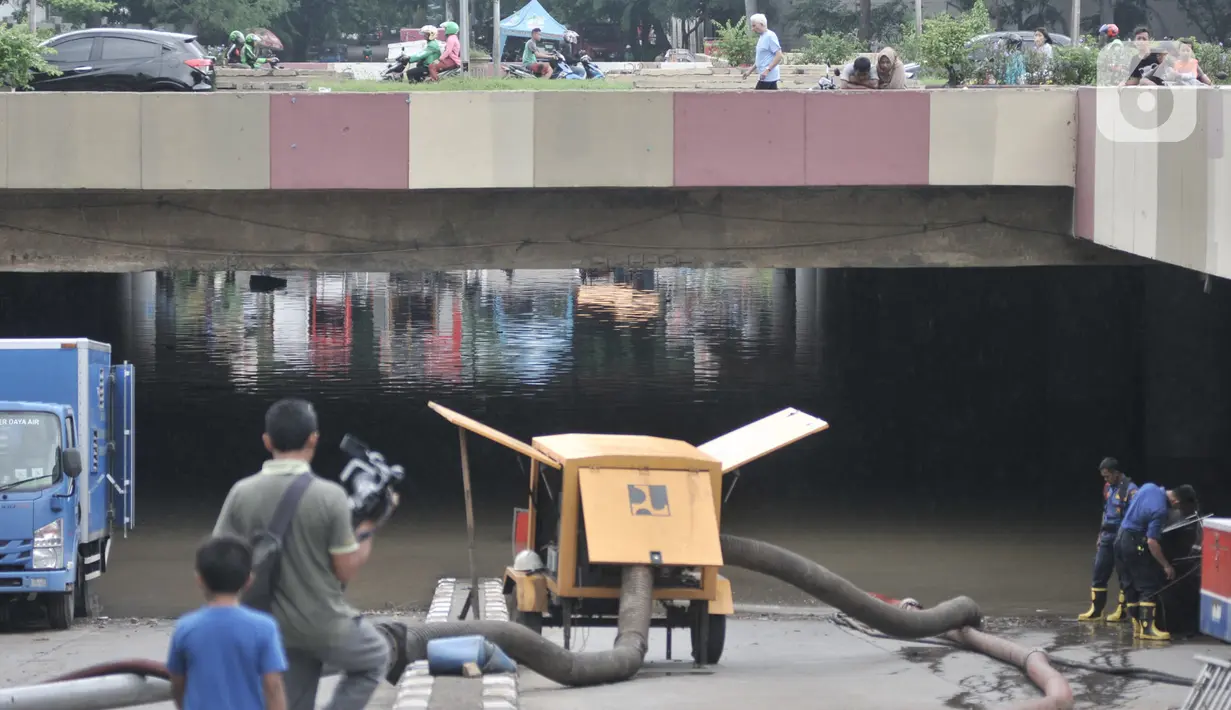 Petugas mengerahkan pompa untuk menyedot banjir di Underpass Kemayoran, Jakarta, Minggu (26/1/2020). Banjir yang terjadi sejak Jumat (24/1) lalu hingga kini belum surut. (merdeka.com/Iqbal S Nugroho)