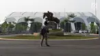 Pewarta melihat-lihat di salah satu pintu masuk kawasan Jakarta International Equestrian Park Pulomas, Jakarta, Kamis (2/8). JIEPP akan menjadi venue tiga cabang equestrian Asian Games 2018. (Liputan6.com/Helmi Fithriansyah)