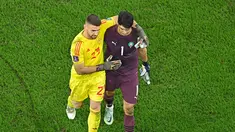 Kiper Spanyol, Unai Simon sempat saling berbincang dengan kiper Maroko, Yassine Bounou, sebelum babak adu penalti pada laga 16 besar Piala Dunia 2022 di Stadion Education City, Selasa (6/12/2022). (AFP/Manan Vatsyayana)