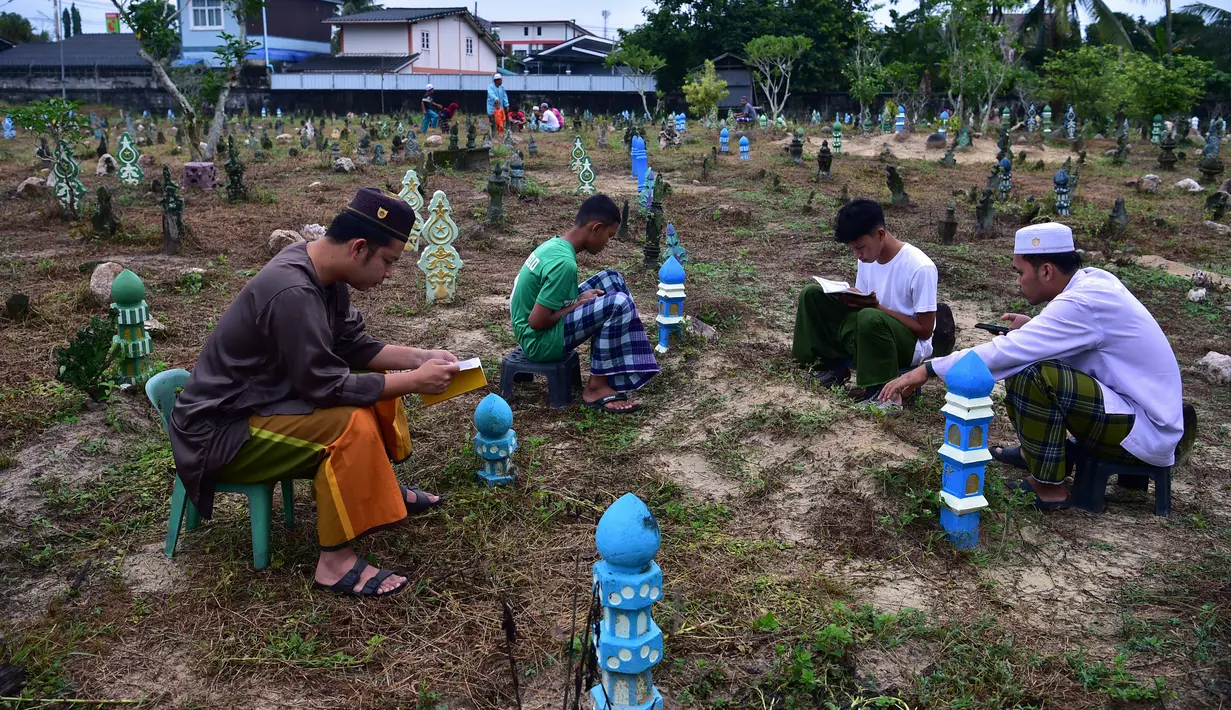 Umat muslim mengunjungi pemakaman saat Idul Adha di Narathiwat, Thailand, 10 Juli 2022. Umat muslim seluruh dunia merayakan Idul Adha atau Hari Raya Kurban untuk memperingati kesediaan Nabi Ibrahim mengorbankan putranya. (Madaree TOHLALA/AFP)