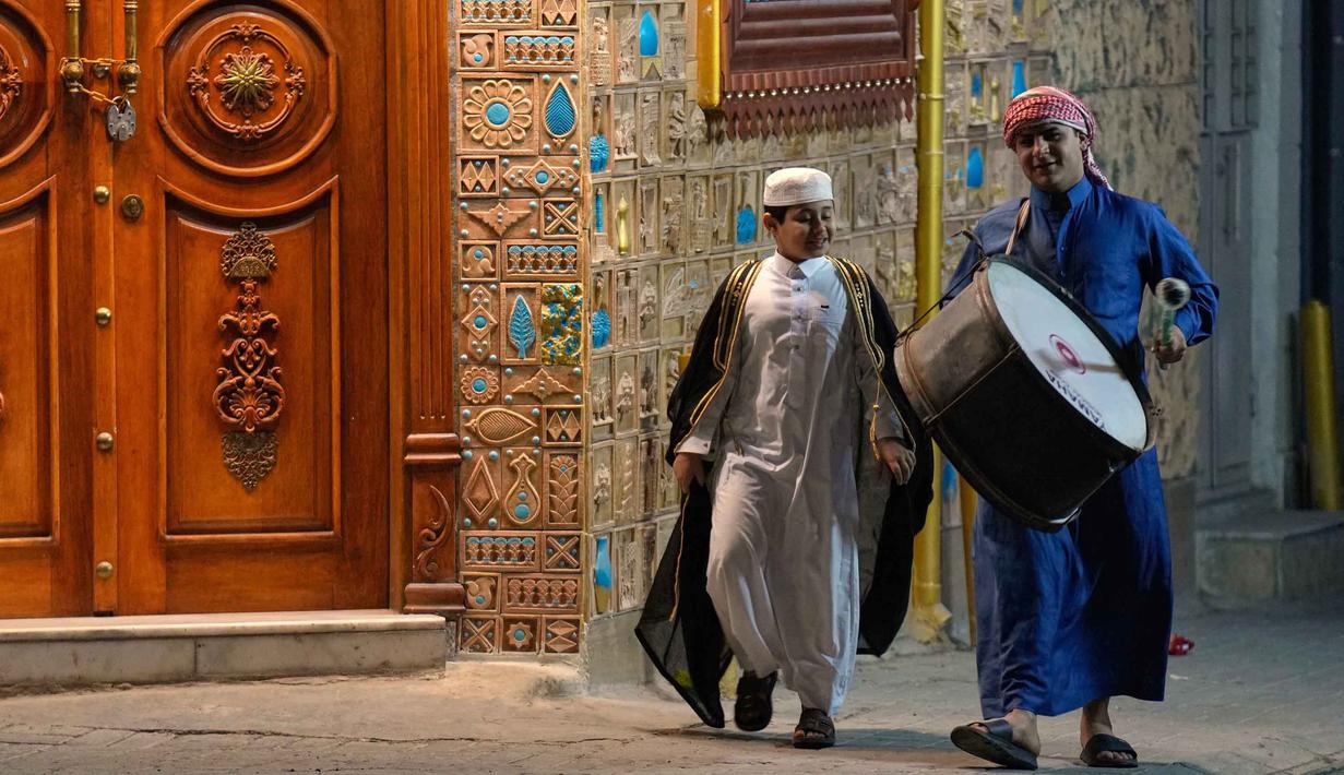 Mesaharati bukan sekadar pengingat waktu, tetapi simbol kebersamaan dan pengabdian sosial. Tampak dalam foto, Wissam Ali, seorang "mesaharati" atau penyeru subuh berusia 22 tahun, saat membangunkan orang-orang untuk makan sebelum matahari terbit, selama bulan suci Ramadan, di lingkungan miskin distrik Fadhil di Baghdad, Irak, Senin 23 Februari 2026. (AP Photo/Hadi Mizban)