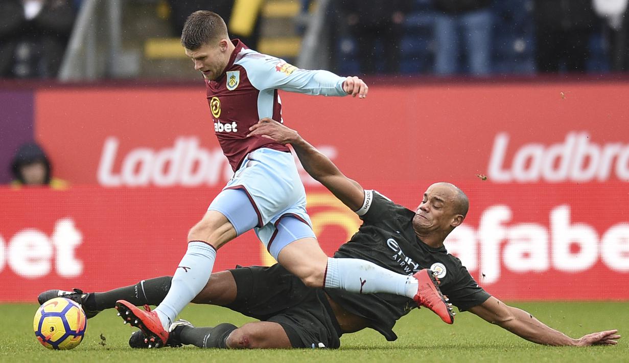 Aksi bek Manchester City, Vincent Kompany (kanan) menghalau bola dari kaki pemain Burnley, Berg Gudmundsson (kiri) pada lanjutan Premier League di Turf Moor  Stadium, Burnley, (3/2/2018). Burnley tahan Manchester City 1-1. (AFP/Oli Scarff)