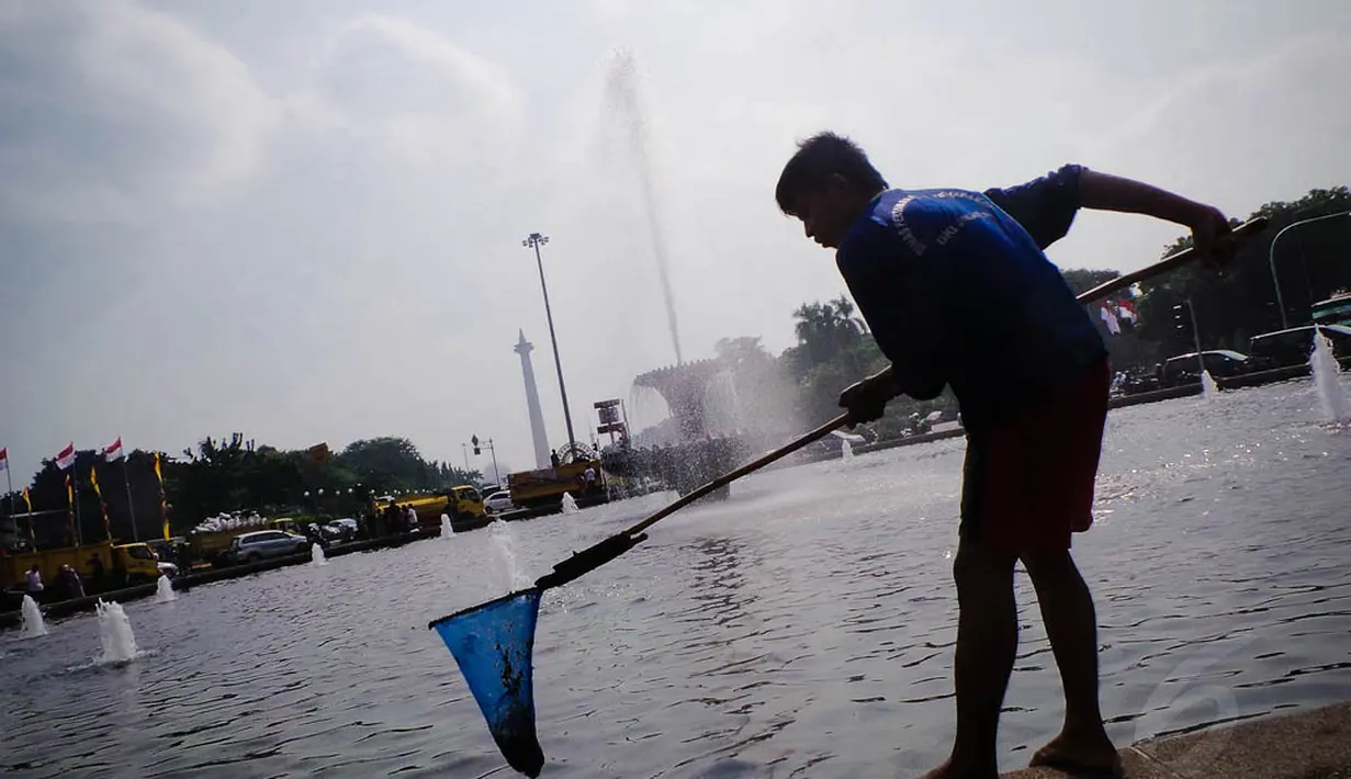 Sekitar 50 personel terlihat tengah bekerja membersihkan sampah yang berserakan di Taman Silang Monas, Jakarta, Jumat (22/8/14). (Liputan6.com/Faizal Fanani)