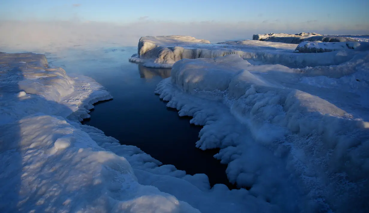 Es menutupi garis pantai Danau Michigan ketika suhu turun hingga -20 derajat F (-29C) di Chicago, Illinois, Rabu (30/1). Suhu di beberapa negara bagian AS menurun drastis, sampai diprediksi bakal lebih dingin dibanding Antartika. (JOSHUA LOTT / AFP)